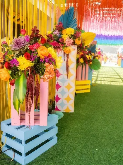 Details of the colorful walkway, with bright floral arrangements on painted wooden crates, adding to the festive and playful carnival atmosphere.