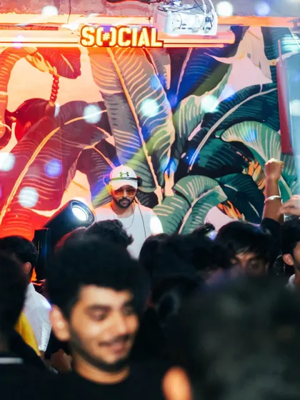 A view from the crowd, looking up at me in the DJ booth. I'm always visible, always part of the party.