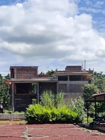 The farmhouse under construction, seen from the areca drying yard.
