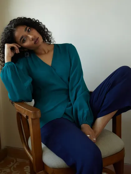 A relaxed and thoughtful portrait for a contemporary fashion label. The rich teal and navy color combination is beautiful, and the natural pose feels authentic and effortless.