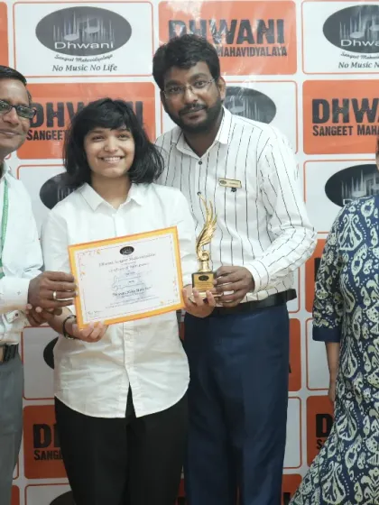 A student receives her award from our faculty, surrounded by her proud family.