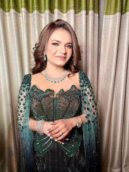 A sophisticated look for a cocktail party or reception. The bride wears a stunning emerald green gown, and her makeup is kept soft and glowing to match.