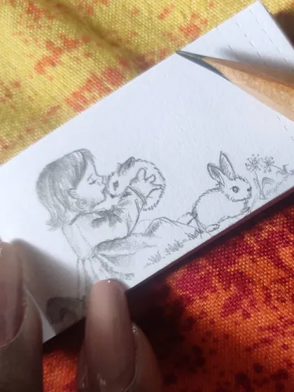 Another angle of the miniature rabbit sketch, showing the fine pencil work required to create detail in such a small space.