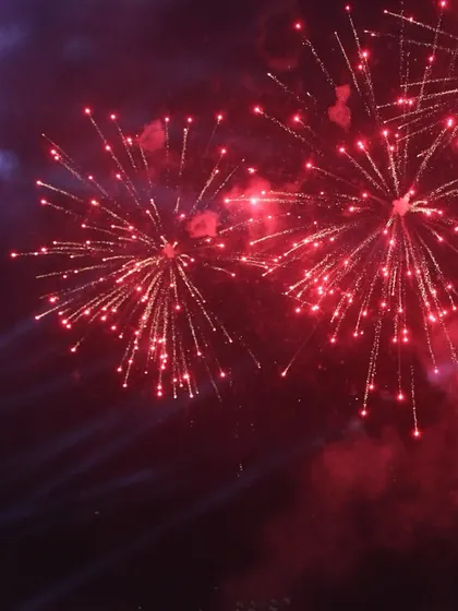 A close up of the vibrant red fireworks bursting against the night sky. Our team works with top pyrotechnic experts to ensure a safe and stunning show.