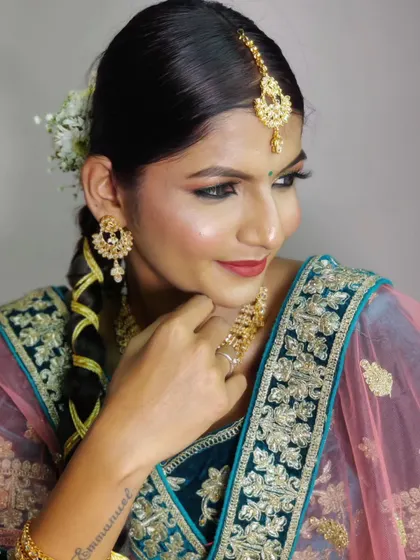 The sleek hairstyle with a parandi and fresh flowers is inspired by Radhika Merchant's wedding look.