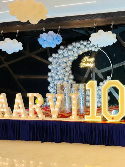 A close-up of the stage decoration for the "sky and clouds" themed event, featuring large light-up marquee letters.