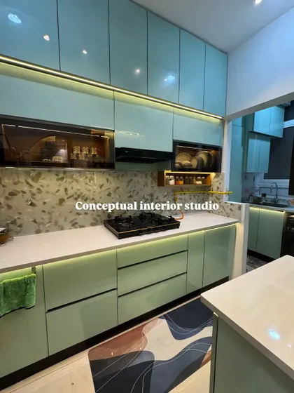Another angle of the pastel-toned kitchen, showing the seamless look of the glossy finish cabinets and the under-cabinet lighting that illuminates the workspace.