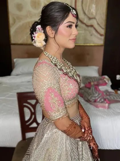 A side profile of a bride with a soft, textured updo adorned with a few flowers. This is a beautiful and modern take on the classic bridal bun.