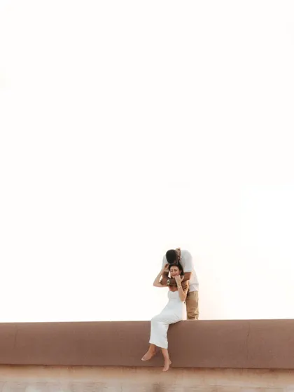 A minimalist composition focusing on a tender moment. The vast, bright background emphasizes the couple's closeness, creating an artistic and modern pre-wedding portrait.