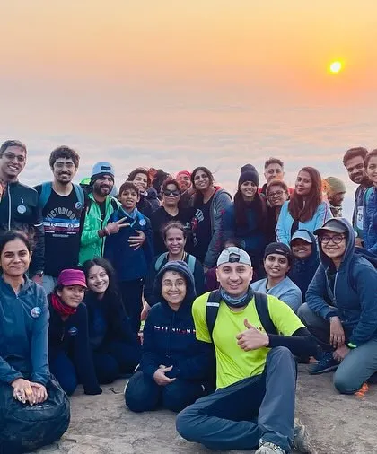 A team celebrates at the summit of a Western Ghats peak during a sunrise trek. We offer a wide range of treks, from easy day hikes to challenging multi-day expeditions.