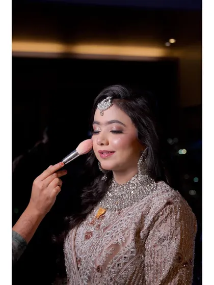 A behind-the-scenes moment, adding the final touch of blush. This is part of the process of creating that perfect, long-lasting glow.