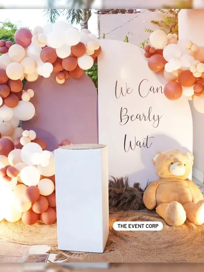 "We Can Bearly Wait!" A sweet and simple backdrop for a teddy bear-themed baby shower, using a neutral color palette of brown and white balloons.