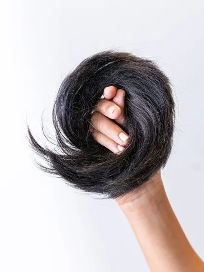 A close-up shot of the Donut Bun, showing the rich texture of the real human hair. It's the perfect accessory for a quick and polished hairstyle.