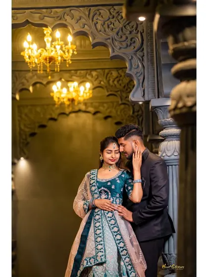 An intimate embrace in a grand, beautifully lit hall. The couple's elegant attire and the architectural details create a luxurious and romantic photo.