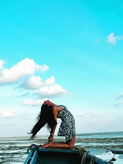 An expressive Ustrasana, or camel pose, on a boat. This heart-opening backbend felt incredibly freeing, with my hair flowing and the vast blue sky above me, connecting me to a feeling of pure openness.