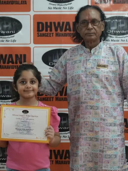A student receives her award from a senior guru, a moment of blessing and recognition.