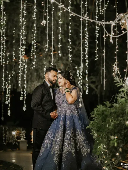 A romantic night-time portrait of the couple under a curtain of fairy lights, creating a magical and intimate setting.