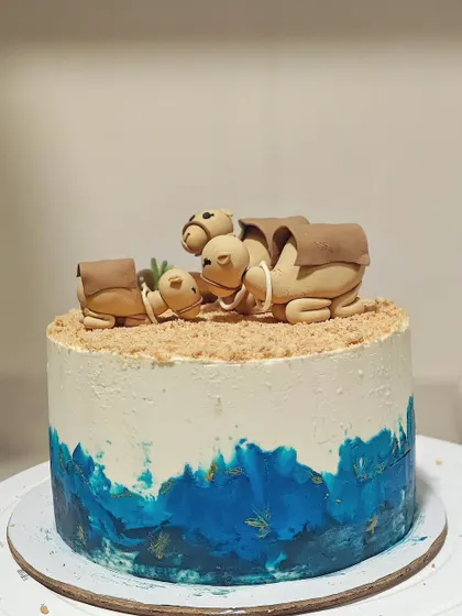 The full camel-themed baby shower cake. I used a blue watercolor effect on the bottom to represent an oasis, adding a pop of color to the design.