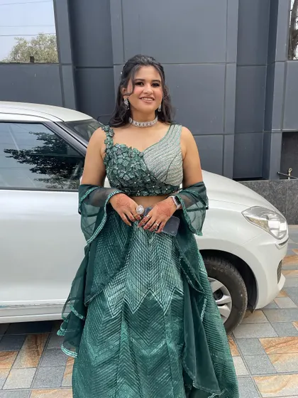 A full-length view of this modern and chic look. The green outfit is a showstopper, and the makeup is the perfect complement.