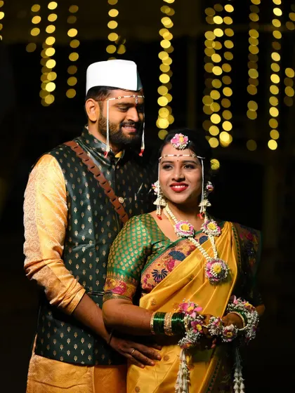 A classic Maharashtrian Haldi portrait. The bride is adorned in a custom floral set featuring pink and yellow flowers, complete with a traditional mundavalya for an authentic touch.