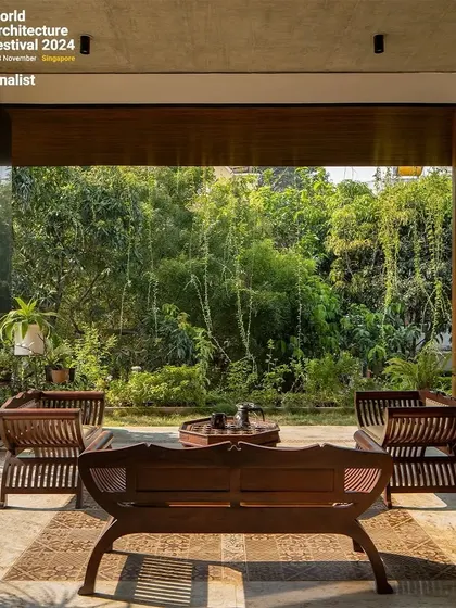 This covered patio demonstrates how I design seamless transitions between indoor and outdoor spaces. The living room opens directly onto this seating area, which is nestled against a backdrop of lush bamboo, creating a tranquil retreat that feels both sheltered and completely open to nature.