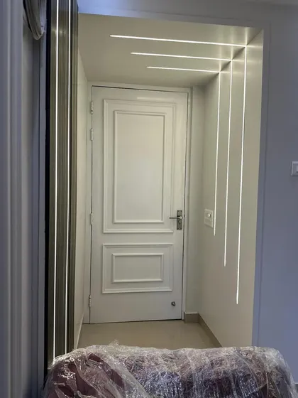 An innovative use of profile lighting to create a graphic feature in a hallway. The clean lines of light run along the wall and across the ceiling, guiding the eye and adding a contemporary architectural element to the space.