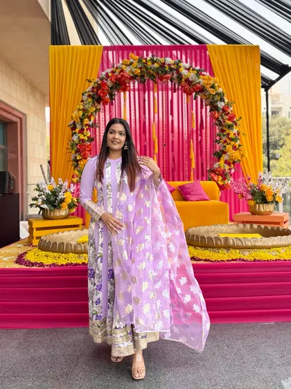 This lilac floral suit set is perfect for a daytime wedding function like a Mehendi. The gold foil print on the organza dupatta adds a touch of festive shine.