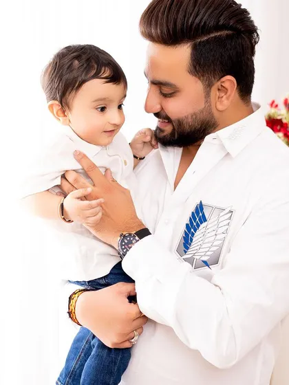 A sweet moment between father and son. The simple white shirts and bright lighting create a clean, classic portrait that focuses on their interaction.