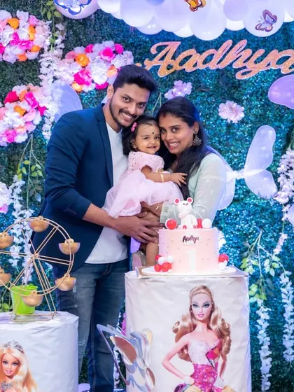 A beautiful family portrait in front of a stunning floral and butterfly backdrop at a first birthday party. We use the event's decor to frame our family photos perfectly.