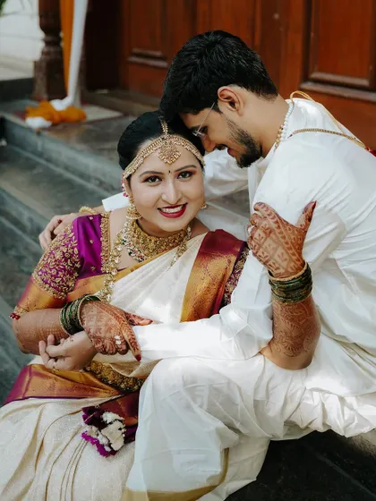 A beautiful, happy portrait of the couple seated on the steps after their wedding ceremony. Their smiles and relaxed posture show their comfort and joy.