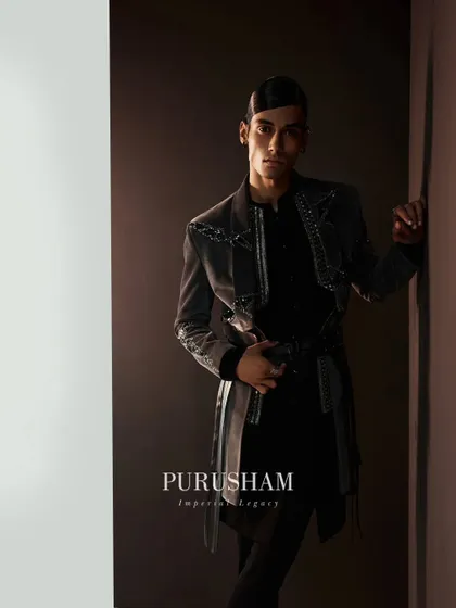 Eternal elegance triumphs. This grey jacket with a unique belted detail and metallic embellishments is a prime example of the rich, layered textures I explore in my winter collections.