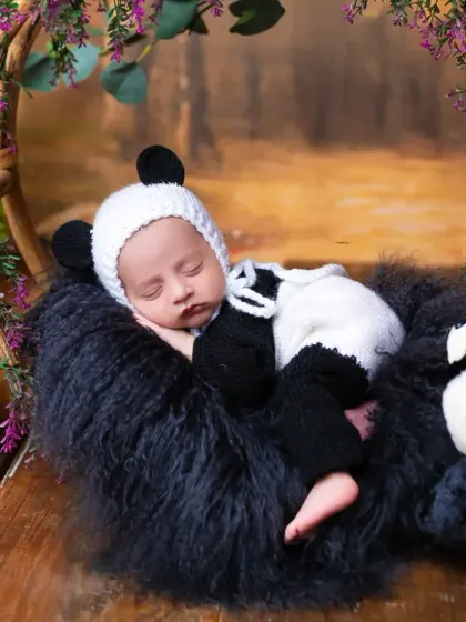 Our little panda cub, sleeping soundly among his fluffy friends. Animal-themed newborn shoots are a wonderfully cute way to capture this fleeting stage.