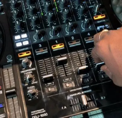 A close-up of my hands on the Pioneer DJ mixer, my primary tool for crafting the perfect musical journey for any event.