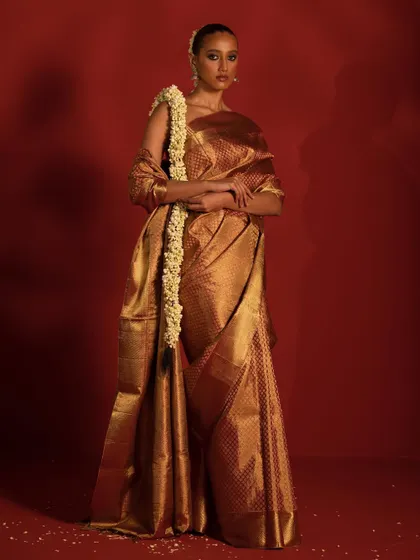 A full-length view of the golden Kanjivaram saree, emphasizing its rich texture and regal drape. This is a must-have for any bridal trousseau.
