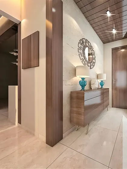 A long entryway is transformed with a sleek wooden console table on hairpin legs. The decorative mirror and lamps add a touch of elegance, while the wooden ceiling detail draws the eye forward.