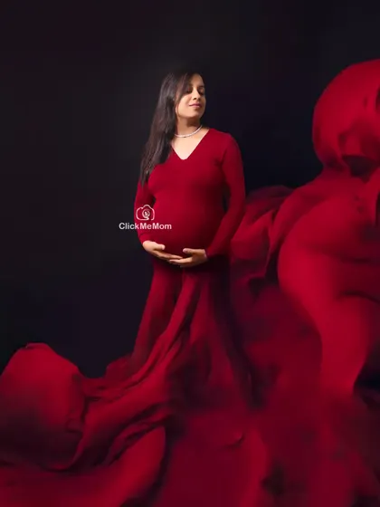Lost in a sea of red. This artistic shot uses waves of flowing red fabric to envelop the mother-to-be, creating a powerful and passionate image that symbolizes the depth of a mother's love.