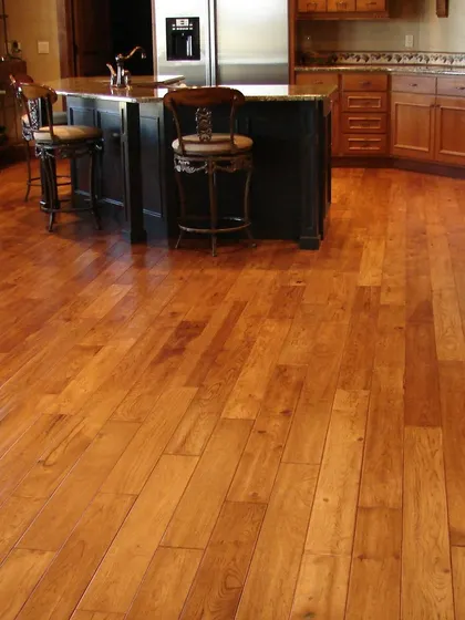 In this kitchen, I installed a durable hardwood floor that can withstand the demands of a busy area. The warm wood tones contrast beautifully with the dark kitchen island, creating a functional and stylish heart of the home.
