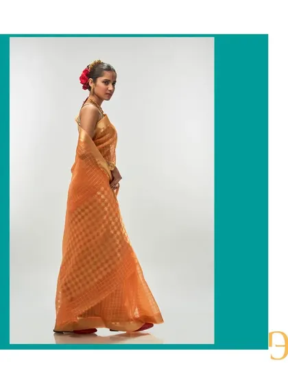 The side profile of the orange iced tea saree, captured to show its graceful fall and elegant silhouette.