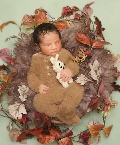 This portrait is part of my autumn series, featuring a baby in a fuzzy bear outfit nestled in a wreath of fall leaves. The textures and colors evoke a sense of warmth and nature.