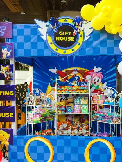 A fantastic gift house setup for a Sonic the Hedgehog party, complete with themed branding and shelves full of prizes.
