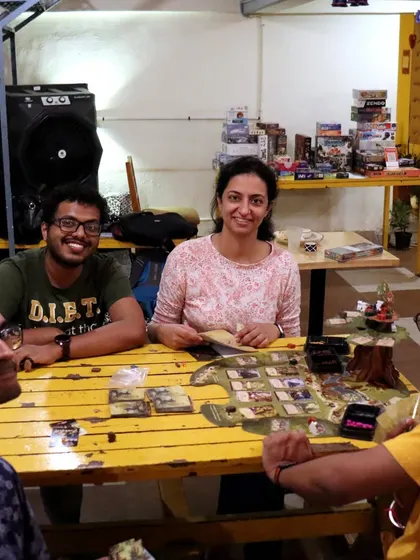 A happy group enjoying a game at our bright yellow table. The variety of games and seating options means there's something for everyone.