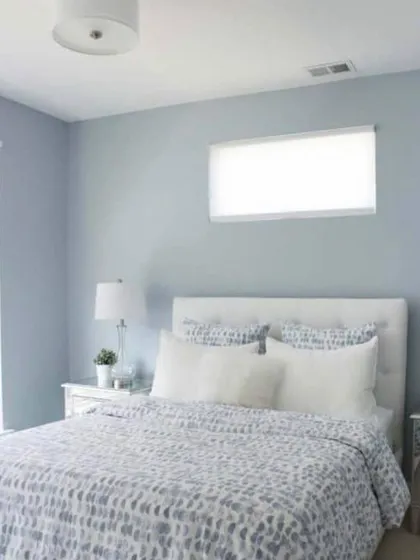 A simple and clean bedroom design with walls painted in a calming shade of periwinkle blue. This color is known for its relaxing properties, making it an excellent choice for a restful bedroom.