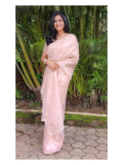 A delicate and dreamy light pink organza saree. This look is soft, romantic, and ideal for an engagement ceremony.