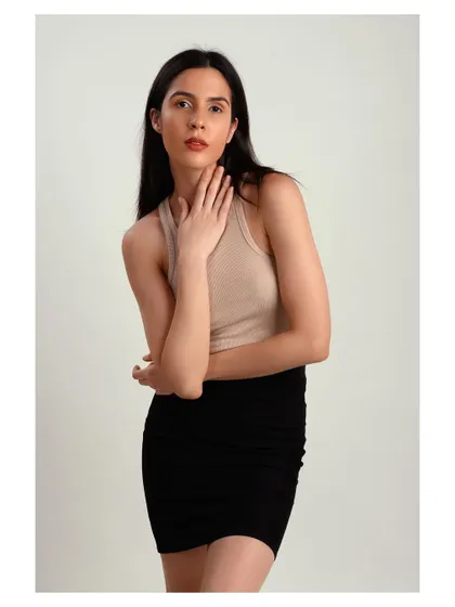 A simple and clean studio portrait. The neutral top and black skirt create a minimalist look that puts the focus entirely on the model.