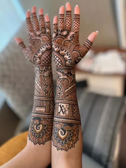 A personalized bridal design featuring the couple's initials and peacock motifs. The peacock feathers wrap around the wrist, creating a beautiful and unique cuff.