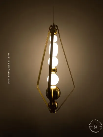 This elegant pendant is framed by a triangular gold structure, enclosing a string of white and gold beads. It's a sophisticated and modern piece that adds a touch of jewelry-like decoration to your space.