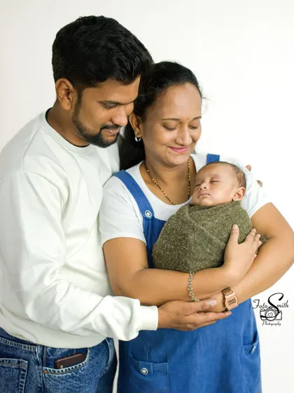 The complete peace of a sleeping newborn in their mother's arms, with dad watching over them. This is what family love looks like in those first few weeks.