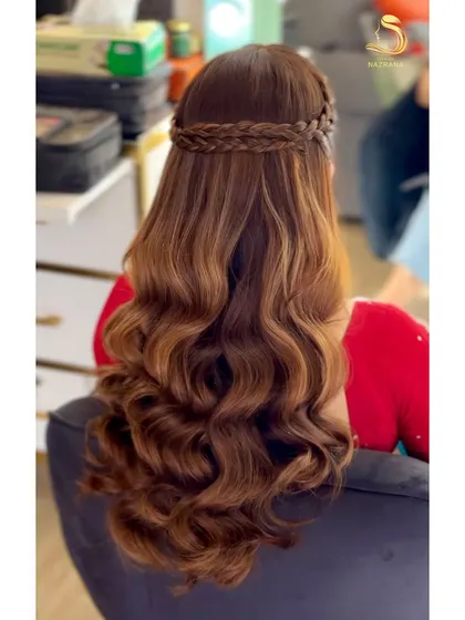 A classic half-up style with a simple crown braid and beautiful, uniform waves. This is a timeless look for a bridesmaid or for an engagement ceremony.