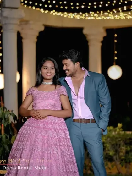 An intimate couple's portrait where the pink lace gown and teal suit complement the romantic, softly lit background.