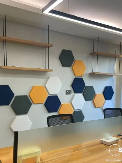 We used hexagonal acoustic panels in company brand colors to create a feature wall in this workspace. This not only adds visual interest but also helps to dampen noise in the open-plan office.